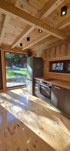 a kitchen with wooden walls and a wooden floor at Bungalows Prokletije in Gusinje