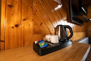 a coffee pot and two mugs on a kitchen counter at Srichan Resorts in Pahalgām