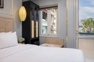 a bedroom with a white bed and a window at Golden Amour Hotel in Hanoi