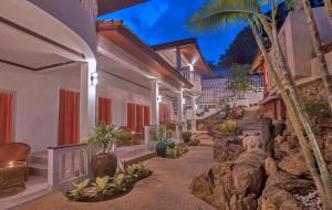 a resort hallway with rocks and palm trees at Samui Little Garden Resort in Chaweng
