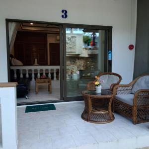 a patio with wicker chairs and a table at Samui Little Garden Resort in Chaweng