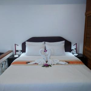 a white bed with a swan decoration on it at Samui Little Garden Resort in Chaweng