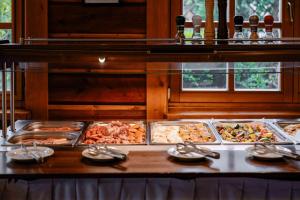 a buffet with many trays of food on a table at Sojka Resort in Bešeňová