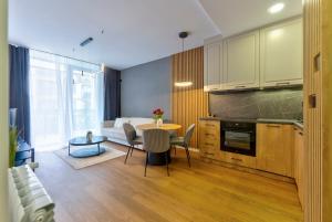 a kitchen and living room with a table and a couch at Apartmani Aurora Zlatibor in Zlatibor