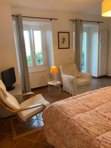 a bedroom with a bed and a couch and a chair at La Meridiana Apartment in Ghiffa