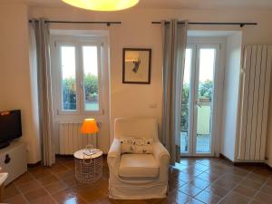 a living room with a chair and a lamp at La Meridiana Apartment in Ghiffa