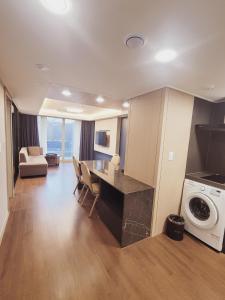 a living room with a dining table and a washing machine at Sokcho Marina Hotel in Sokcho