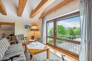 a living room with a couch and a large window at Haus "Sonnenblume" in Regenstauf
