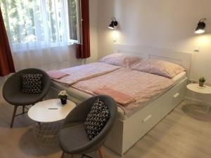 a bedroom with a bed with two chairs and a table at Tekergő Vendégház in Balatonfüred