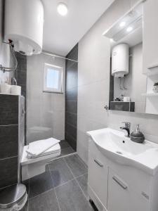 a white bathroom with a sink and a toilet at Apartments Miš in Trebinje +52 photos