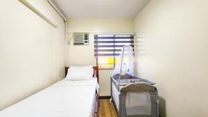 a small room with a bed and a tv at 2BR Fully Air-Conditioned Staycation with Parking in Manila +76 photos