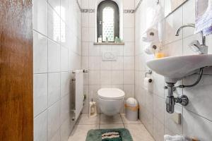 a white bathroom with a sink and a toilet at Haus "Sonnenblume" in Regenstauf +22 photos