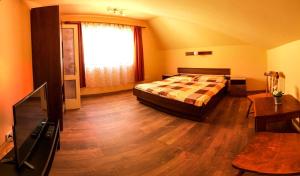 a bedroom with a bed and a flat screen tv at Tekergő Vendégház in Balatonfüred