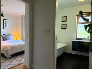 a bedroom with a bed and a tub and a window at Birch House Ballina in Ballina