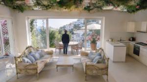 ein Wohnzimmer mit Sofas und eine Person, die in einer Küche steht in der Unterkunft Prima Stella in Positano + 23 Fotos