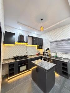 a kitchen with black cabinets and a counter top at EK Escape and Suites in Ado Ekiti