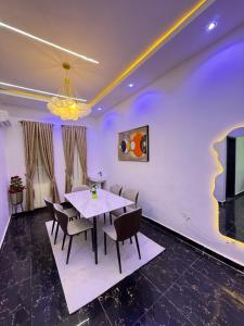 a dining room with a white table and chairs at EK Escape and Suites in Ado Ekiti