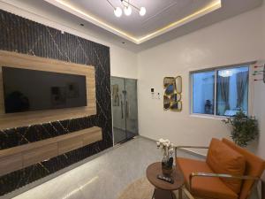 a living room with a television and a couch and a table at EK Escape and Suites in Ado Ekiti
