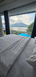 a bed in a room with a large window at Adelisca Glamping, Cafe and Villa in Kubupenlokan