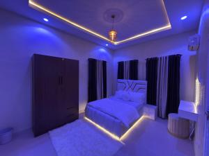 a purple bedroom with a bed and a dresser at EK Escape and Suites in Ado Ekiti