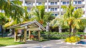 a gazebo in front of a building with palm trees at 2BR Fully Air-Conditioned Staycation with Parking in Manila