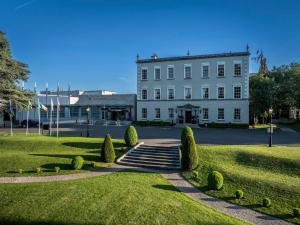 a large white building with a lawn and bushes at Dunboyne Apartment in Dunboyne