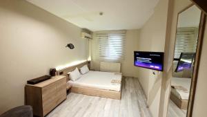 a small room with a bed and a television at Buhara 93 House - Sultanahmet in Istanbul