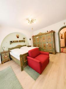 a bedroom with a bed and a red chair at Ferienwohnung Hinterthal in Hinterthal