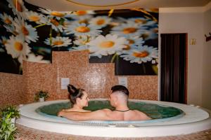 a man and woman sitting in a bath tub at Sojka Resort in Bešeňová
