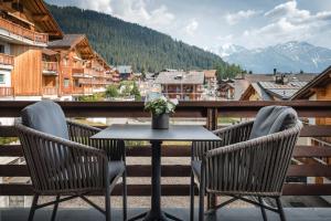 a table and two chairs on a balcony with a view at Hotel Bristol Verbier in Verbier