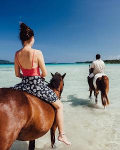 two people riding horses on the beach at Ratua Private Island Resort in Aimbuei Bay +16 photos