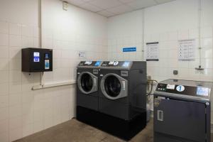 a laundry room with two washing machines in it at Ténéo Apparthôtel Bordeaux Maritime - Cité du vin in Bordeaux