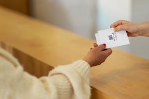 a person holding a card in their hands at Falstadsenteret Hotell - Museum, minnested og senter for menneskerettigheter in Levanger