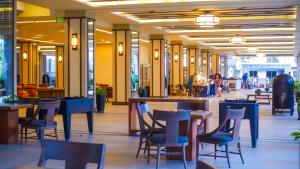 a restaurant with tables and chairs and people walking around at 2BR Fully Air-Conditioned Staycation with Parking in Manila