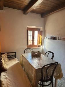 a room with a table and chairs and a window at B&B Pudzones in Santu Lussurgiu