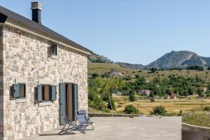 a building with two chairs sitting outside of it at Villa Elena in Cetinje