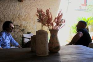 two people sitting at a table with a vase with flowers at Le Casette della Murgia in Cassano delle Murge