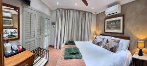 a bedroom with a large white bed and a window at Be Our Guest Accommodation in Klerksdorp