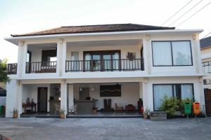 a large white house with a balcony at Alami Apartment Seminyak in Seminyak