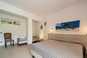 een slaapkamer met een bed en een stoel erin bij Hotel Punta Pina in Portoferraio +58 foto's