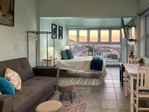 a living room with a bed and a couch at The Sundowner Room in Langebaan
