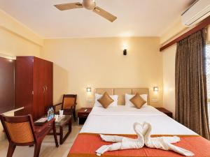 a hotel room with a bed with towels on it at Hotel Golden Wave Puri - Baliapanda Housing Colony - Near Golden Beach- Parking - Restaurant in Puri +4 photos