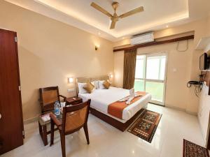 a hotel room with a bed and a desk and a window at Hotel Golden Wave Puri - Baliapanda Housing Colony - Near Golden Beach- Parking - Restaurant in Puri