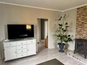 a living room with a television on a white dresser at Arctic View Apartament Vardø in Vardø