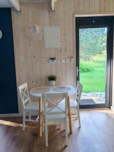 a white table and chairs in a room with a window at Całoroczny domek Morze in Ustka