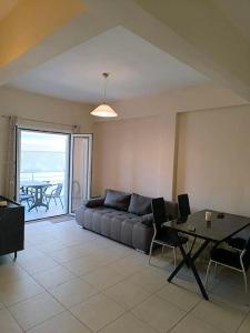 a living room with a couch and a table at George apartment in Artemida