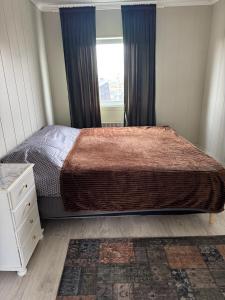 a bedroom with a large bed and a window at Arctic View Apartament Vardø in Vardø