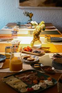 a table with plates of food and a vase of flowers at L'Abbraccio della Quercia - Suites in Buje +73 photos
