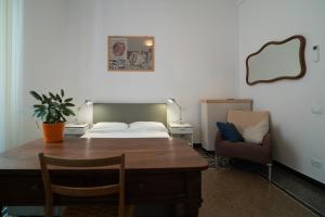 a room with a table and a bed and a chair at B&B BnBeach in Varazze