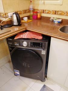 a washing machine under a counter in a kitchen at White Pearl Apartment in Alexandria